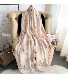 Detail of silk-like floral scarf draped on chair in elegant home setting scene