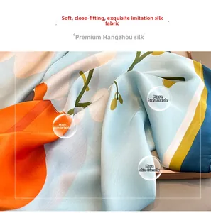 Close-up of soft faux silk scarf featuring vibrant orange flowers and blue texture