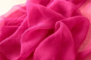 Makro-Detail des eleganten rosenroten transparenten Stoffes mit natürlicher Faltenstruktur