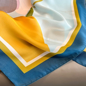 Sciarpa di seta colorata con motivi blu e gialli che mostra consistenza morbida e lucida