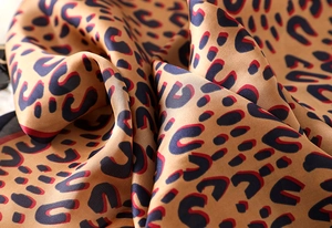 Macro shot of silk leopard print scarf with smooth texture and rich color drape