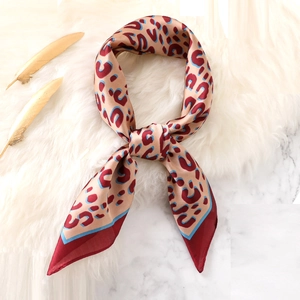 Fashionable leopard print silk scarf with red border and warm camel tones for women