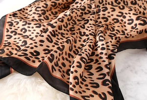 Close-up of leopard print silk scarf showing smooth texture and elegant black border