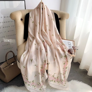 Elegant floral silk-like scarf for women, lightweight pink drape on a beige armchair