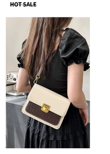 Detail of crossbody bag featuring cream smooth leather and brown crocodile pattern