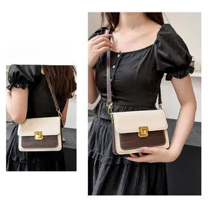 Detail of two-tone crossbody bag with cream flap and dark brown crocodile pattern texture