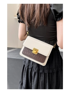 Detail of vintage square crossbody bag with brown croc-embossed panel on neutral outfit