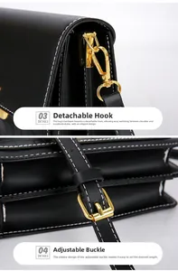Detail of black leather handbag with gold metal hooks and white contrast stitching