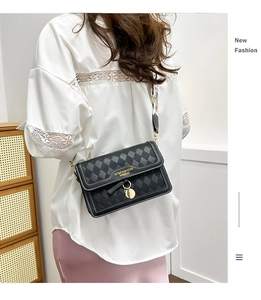 Rear view of black quilted crossbody bag with a decorative wide graphic shoulder strap