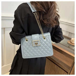 Detailed view of the light blue quilted pattern shoulder bag with a gold metal chain strap