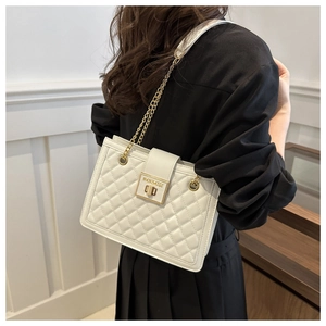 Close-up of elegant quilted texture and gold chain strap on white leather shoulder bag