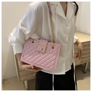 Detail of pink quilted crossbody bag with gold chain strap and metallic twist lock