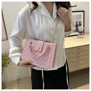 Close-up of pink quilted crossbody bag with gold metal lock and elegant chain strap