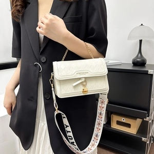 White quilted crossbody bag with golden chain handle and vintage jacquard wide strap