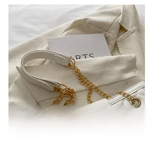 Detail of white quilted handbag featuring gold-tone metal twist lock and chain strap