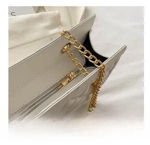 Close-up of smooth gold zipper and luxury quilted white leather on fashion chain bag