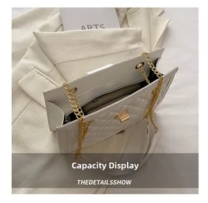 Detailed view of the white quilted leather bag interior and gold chain strap