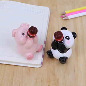 Cute pig and panda desk ornaments holding small jars on a modern office table