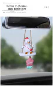 Macro detail of MOMO duck car pendant with resin swing and pink flower on rearview mirror