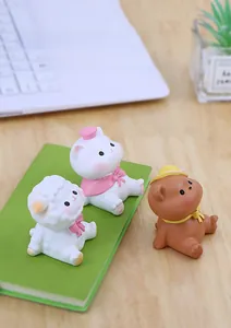 Detailed close-up of cute resin animal figurines sitting on a notebook for desk decor