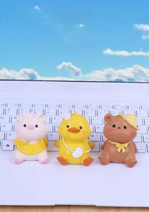 Detailed close-up of cute resin animal figures on a laptop with a blue sky background
