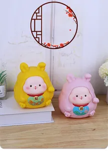 Detail of yellow and pink rabbit figurines with Chinese lucky characters on wooden desk