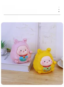 Detail of pink and yellow rabbit money boxes on a wooden table for home decoration