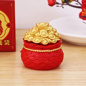 Close-up of red fortune bag ornament with gold ingots for car and desk decoration
