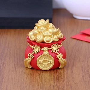 Close-up of red fortune bag with gold ingots for car dashboard or office desk decor