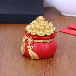 Close-up of a red Chinese money bag ornament with gold ingots and a ruyi knot tassel
