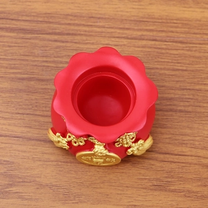 Close-up of red money bag ornament with gold lucky coins and Chinese knot on wood
