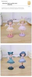 Détail de quatre figurines de fées colorées avec ailes sur une surface en bois