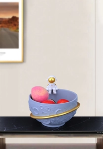 Detail view of astronaut storage bowl with moon surface texture and gold planet ring