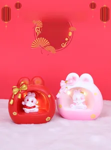 Detailed view of rabbit night lights in red and pink with warm LED lights and golden bows
