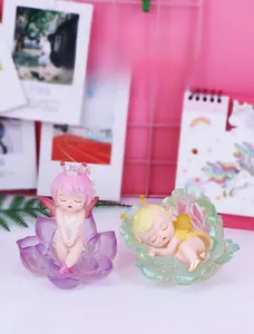 Detail showing two cute fairy figurines Sleeping in flower petals on a shelf