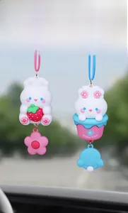 Close-up of cute rabbit car charms with strawberry and milky tea cup designs hanging in car