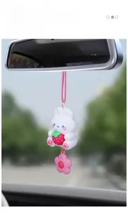 Close-up of a cute white rabbit car hanging ornament with a strawberry on rearview mirror