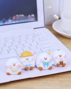 Close-up of four cute bird figurines with summer accessories on a white laptop keyboard