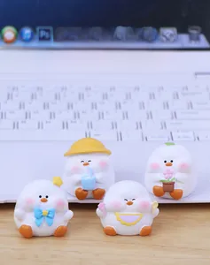 Detailed close-up of four cute cartoon duck desk ornaments on a wooden table surface
