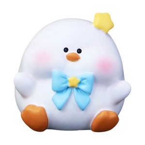 Cute white cartoon duck desk ornament with blue bow tie and yellow star on white background