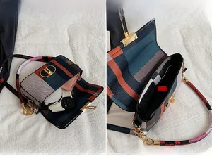 Detail showing the main pocket capacity of the plaid crossbody bag with a gold metal buckle