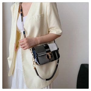 Detail of color-block plaid crossbody bag with gold T-lock and chain strap on model