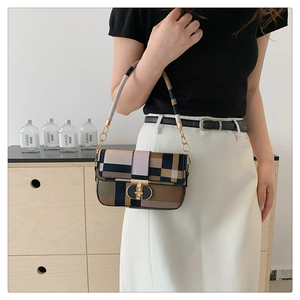 Close-up of geometric color block crossbody bag with gold metallic clasp detail