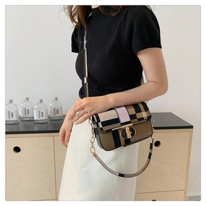 Retro plaid crossbody bag with gold metal lock shown on a model in a warm indoor setting
