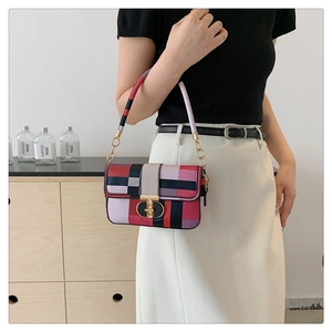 Close-up of contrast plaid bag with golden metal buckle and woven chain shoulder strap