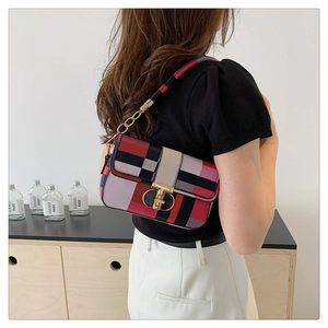 Detail showing colorful plaid patchwork handbag with gold metal lock and chain strap