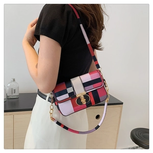 Detailed view of geometric patchwork crossbody bag with metallic rotary lock on a model