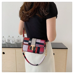 Detail of multi-color plaid crossbody bag with wide woven strap on a female model