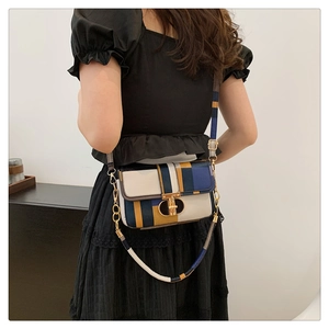 Detail of color-block crossbody bag with geometric leather panels and gold vertical lock
