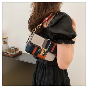 Detail of color-block plaid crossbody bag featuring a vintage gold twist lock and chain strap